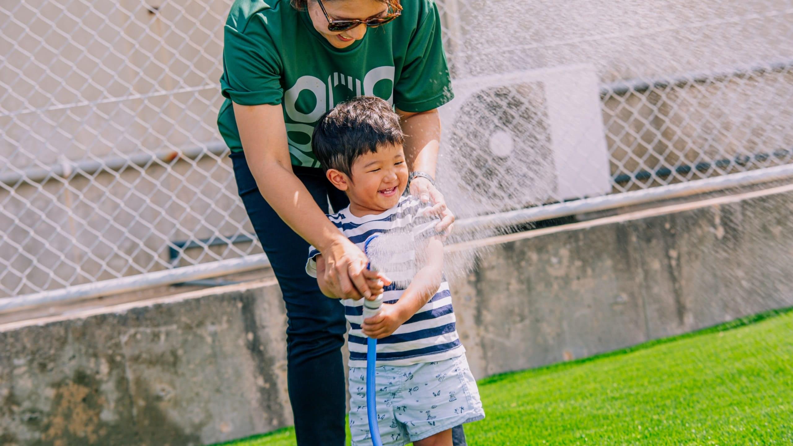 COOOL Turf（クールターフ）に水を撒く子ども