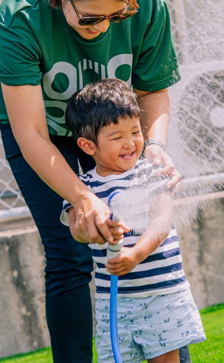 COOOL Turf（クールターフ）に水を撒く子ども